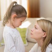 Beautiful mother is comforting her sad little daughter at home. Family relationships.