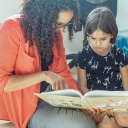Social worker and child reading book