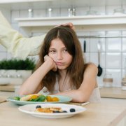 Sad girl at dinner table